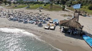 eine Luftansicht auf einen Strand mit Stühlen und Sonnenschirmen in der Unterkunft Tigaki Mall Hostel in Tigaki