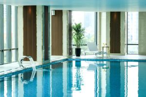 a swimming pool in a building with a laptop at Grand Vista Hanoi in Hanoi