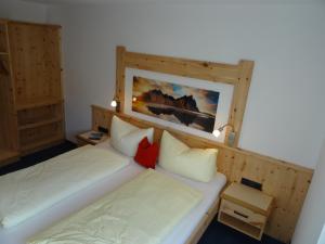 ウダーンスにあるAppartmenthaus Tischnerのベッドルーム1室(ベッド2台付)が備わります。壁には絵画が飾られています。