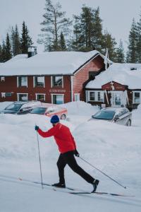 Facet biegnie na nartach w śniegu w obiekcie Kuerkievari KuerHostel w mieście Äkäslompolo