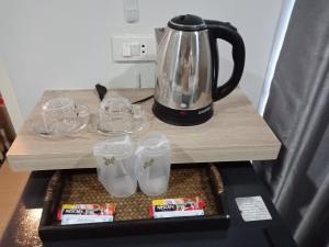 a table with glasses and a tea kettle on it at Wish Hotel Ubon in Ubon Ratchathani