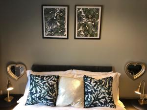 a bedroom with three framed pictures above a bed at 3. Stylish Private Double Room Near Manchester City Centre in Manchester
