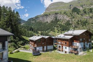 an aerial view of two buildings in front of a mountain at Chalet Monte Cristo in Zermatt
