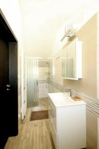 a white bathroom with a shower and a sink at Sklep s penzionem Kozojídky in Kozojídky