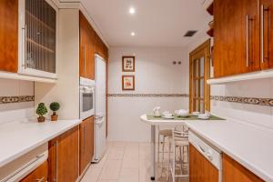 a kitchen with white counters and wooden cabinets at Flex Apartment Granada by A3Rentals in Granada