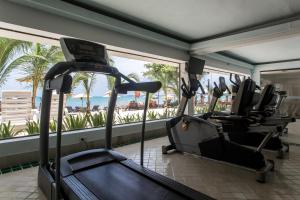 - une salle de sport avec une rangée de vélos d'exercice devant une fenêtre dans l'établissement Samui Buri Beach Resort, à Mae Nam Beach