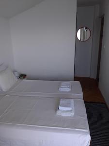 two beds in a room with two towels on them at Vila Idila in Ohrid
