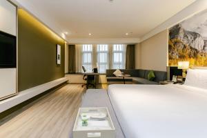 a hotel room with a large bed and a living room at Atour Hotel Chengdu Shuangliu International Airport in Chengdu