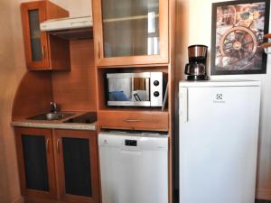 a small kitchen with a refrigerator and a microwave at Les yeux dans l'océan in Le Croisic