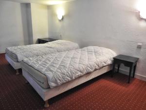 a small bed in a room with two tables at Les yeux dans l'océan in Le Croisic