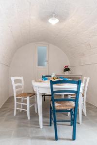 una sala da pranzo con tavolo e sedie bianchi di D'aprile Dimore a Polignano a Mare