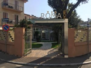 une porte menant à un bâtiment avec un panneau indiquant : dans l'établissement Hotel Roma, à Marina di Massa