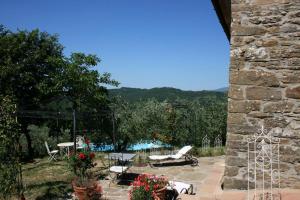 a patio with chairs and tables and a pool at La Casina del Bosco in Subbiano