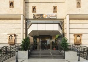 a hotel entrance with stairs in front of a building at شقق حديقة الزهور 1 للشقق المخدومة in Yanbu