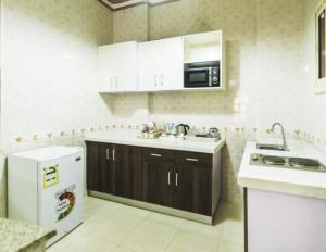 a small kitchen with a sink and a microwave at شقق حديقة الزهور 1 للشقق المخدومة in Yanbu