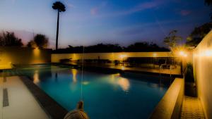 uma grande piscina à noite com luzes em GTV Hotel em Cikarang