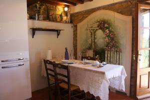 a dining room with a table and a painting on the wall at La Casina del Bosco in Subbiano