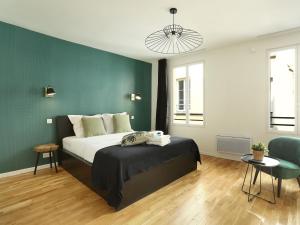 um quarto com uma cama e uma parede verde em Rent a Room - Residence Caire, Montorgueil em Paris