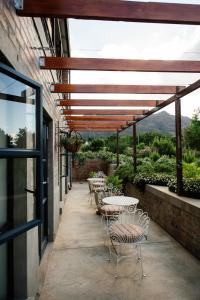 a row of tables and chairs on a patio at Vineyard Views Country House in Riebeek-Kasteel