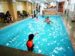a group of children playing in a swimming pool at suradeep residency in Mahabalipuram