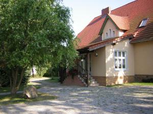 a house with a red roof and a tree at Ferienwohnung Marienkäfer in Wulkow