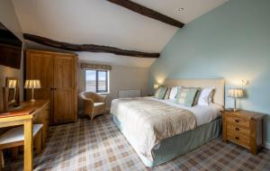 a bedroom with a bed and a desk and a chair at The Inn at Ravenglass in Ravenglass