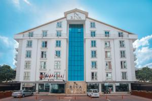 un gran edificio blanco con un cartel. en Riva Reşatbey Luxury Hotel, en Adana