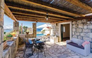 a patio with a table and chairs on a stone wall at Villa Maestral in Brsečine