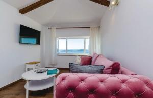 a living room with a pink couch and a table at Villa Maestral in Brsečine