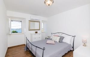 a white bedroom with a bed and a window at Villa Maestral in Brsečine +25 photos