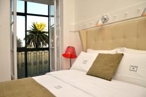 1 dormitorio con cama blanca y balcón en Casa Oliver Boutique B&B - Principe Real, en Lisboa