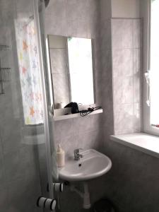 a bathroom with a sink and a mirror at Pension Mois in Wurz