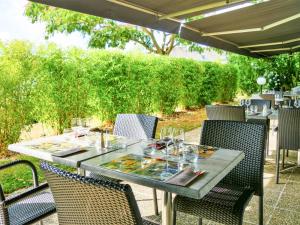 an outdoor table with chairs and an umbrella at ibis Laval Le Relais D'Armor in Laval