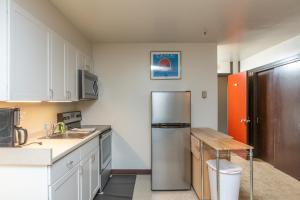 una cucina con frigorifero in acciaio inossidabile e tavolo di East Condo #208 a Girdwood