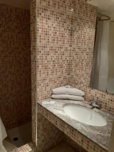 een badkamer met een wastafel en een spiegel bij HOTEL CONTINENTAL Khénifra in Khenifra