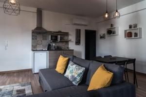 a living room with a blue couch with yellow pillows at Redondo Loft in Macedo de Cavaleiros