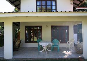 una casa con patio con mesa y sillas en La Rocaille, en Baie Lazare Mahé