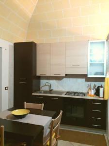 uma cozinha com uma mesa e um fogão forno superior em Casa Libertà 32 em Marsala