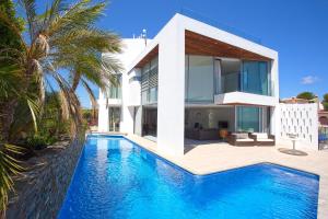 a house with a swimming pool in front of a house at Macarius in Jávea