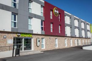 een hotel met een rood-wit gebouw bij B&B HOTEL Sainte-Maxime Golfe de Saint Tropez in Sainte-Maxime