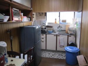 una pequeña cocina con nevera y fregadero en Guesthouse Kotohira, en Kotohira