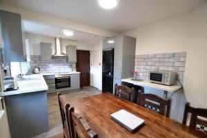 una cucina e una sala da pranzo con tavolo in legno di 14 Castle View Red Lake a Telford