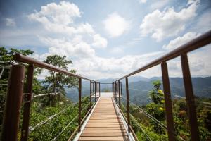 Una pasarela de madera en las montañas con vistas en Red House the Garden Stay in Bukit Tinggi by PLAY, en Bentong