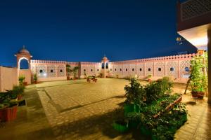 a large building with a courtyard with potted plants at Hotel Jaisingh Palace in Jaipur