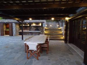 una mesa y sillas en un patio con escaleras en Τείχιο Βίλα - Tihio Villa - Πετρόχτιστη βίλα, en Tíkhion