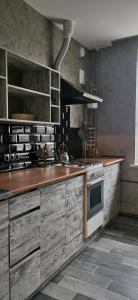 a kitchen with wooden cabinets and a stove at Loft style apartments in the center in Sumy