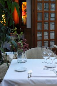 a table with glasses and a vase of flowers on it at Hotel Milan in Pula
