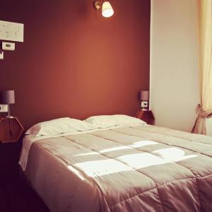 ein großes Bett in einem Schlafzimmer mit zwei Lampen in der Unterkunft Hotel Monte Mazzoccone in Quarna Sopra