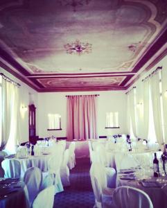 uma sala de banquetes com mesas brancas e cadeiras brancas em Hotel Monte Mazzoccone em Quarna Sopra