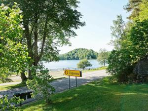6 person holiday home in ULLARED في أولاريد: وجود علامة على شارع بجانب البحيرة